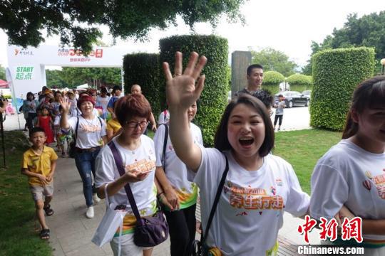 在发令枪声响起后,身穿活动T恤的养生爱好者共同迈步出发。 钟欣 摄