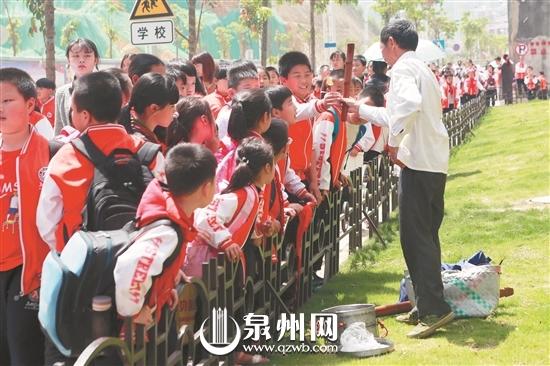 放学后,不少学生围到摊点前购买小吃。