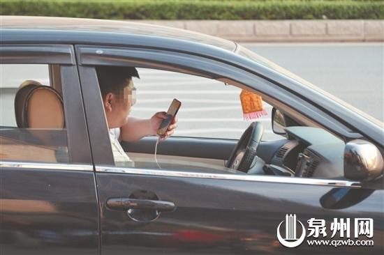 不少司机在等待信号灯时会使用手机