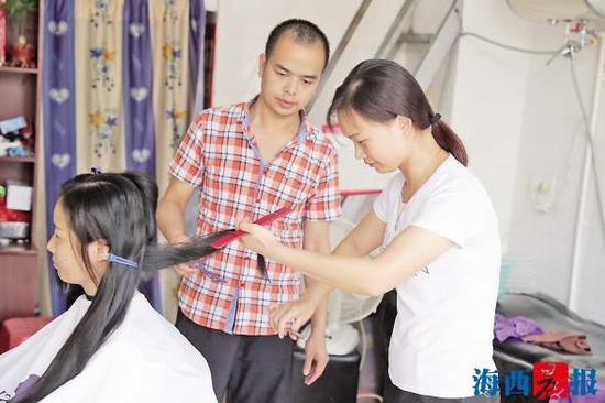 陈保忠夫妻俩为客人理发。记者 陈理杰 摄