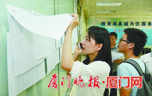 家长们在公告栏查询派位结果。