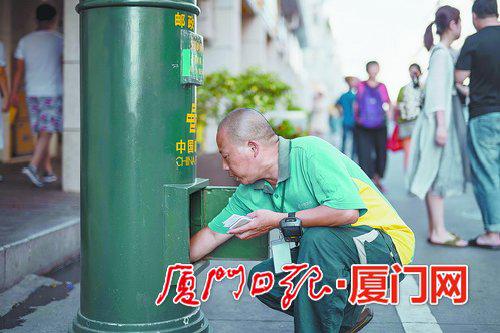 陈明利在中山路的邮筒收取当日的信件。