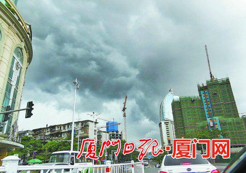 昨日时有阵雨,市区上空乌云滚滚。(本报记者姚 凡摄)