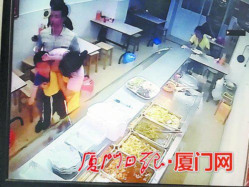 监控视频显示:孩子被踢倒后,蓝先生的爱人将孩子抱起,蓝先生也冲了过来。
